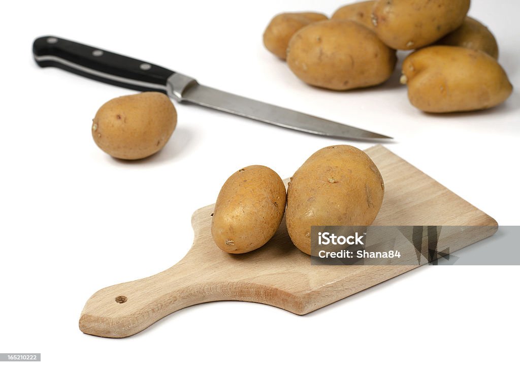 Batatas em uma tábua de cortar de madeira - Foto de stock de Alimentação Saudável royalty-free