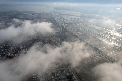 Aerial view of houses and salt fields in a foggy town