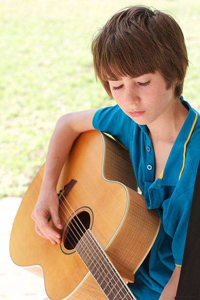 istock Teenage boy looking downwards with guitar 165211787