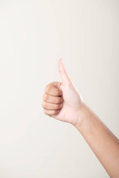 istock Female hand thumbs up hand gesture on grey background 1652153166