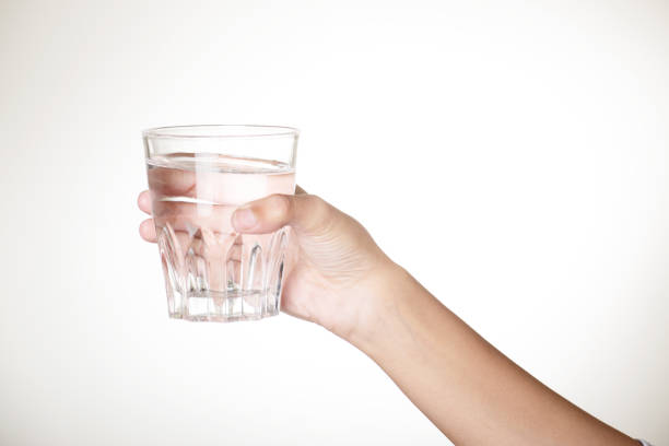 istock Water glass in hand on grey background 1652153744