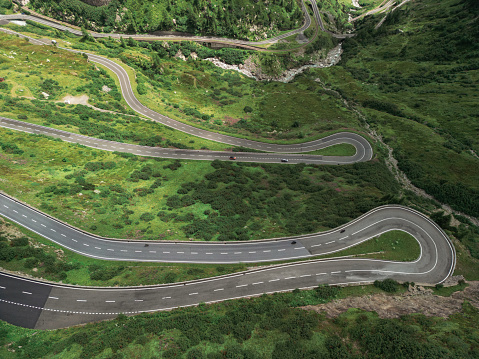 An aerial view of the majestic fog-covered green mountains and winding Transfagarasan road