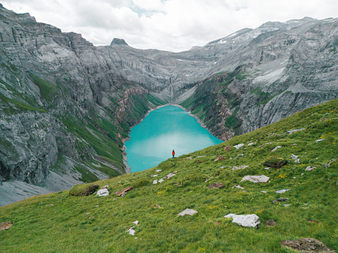 Aerial view of woman in red coat looking at Limmersee in Swiss Alps