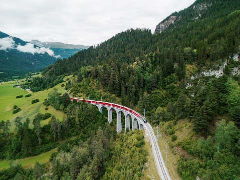 Aerial view of red train on viaduct in Swiss Alps