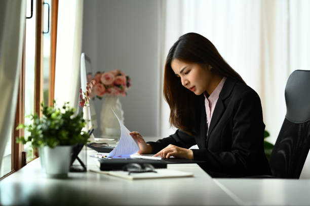 istock Serious asian woman economist reading paper document, analyzing marketing data, statistics, financial results at desk 1652289677