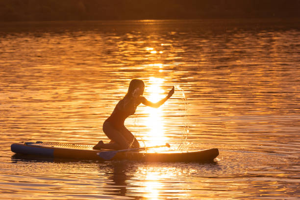 istock Woman silhouette sitting on supboard at sunset. 1652308030