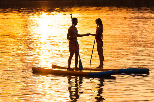 istock Sea woman and man on sup board have active rest. 1652308409