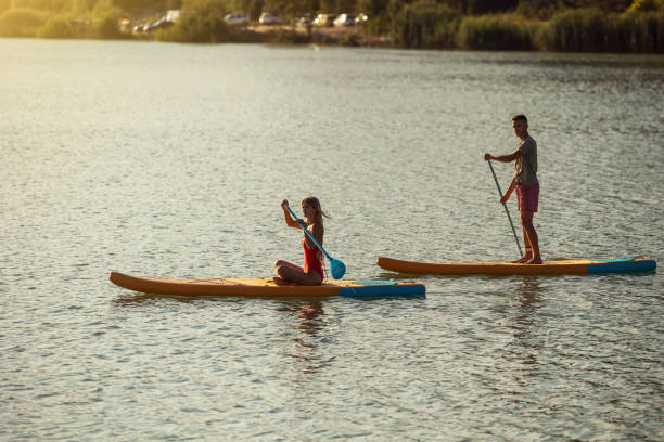 istock Couple on supboards surfing in river or lake. 1652308956