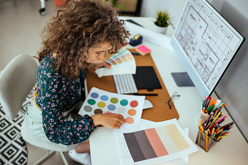 Female designer holding color swatches in her office