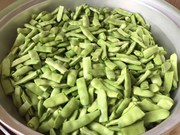 haricots verts frais dans une grande casserole pour la cuisson - greenbean casserole photos et images de collection