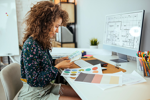 Female designer holding color swatches in her office