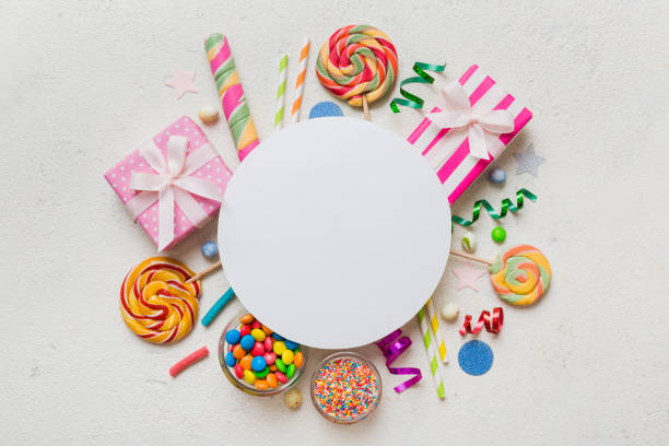 istock Flat lay holiday composition. Paper blank, lollipop, birthday decorations on Colored background. Top view, copy space for text 1652323628