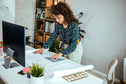 Female designer in office working on architects project