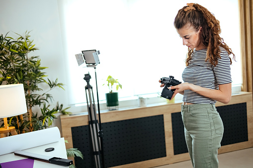 Young photographer working at her home office.