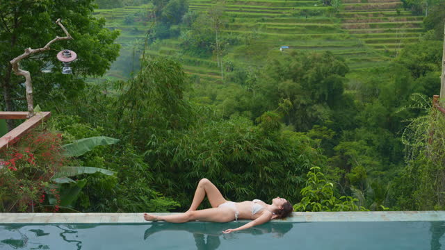 Woman relaxing at the pool on villa on Bali
