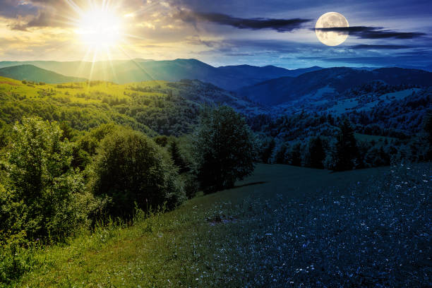 istock mountain landscape in summertime with sun and moon at twilight 1652347594