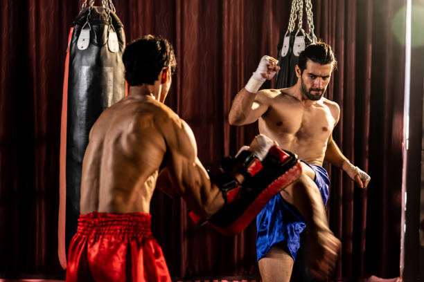 asian and caucasian boxer unleash kick attack in training. impetus - impetus imagens e fotografias de stock