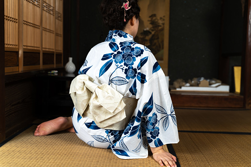 A woman in a yukata sitting on a tatami mat