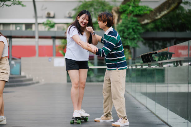 istock Asian Chinese young friends learning skateboard. 1652374920