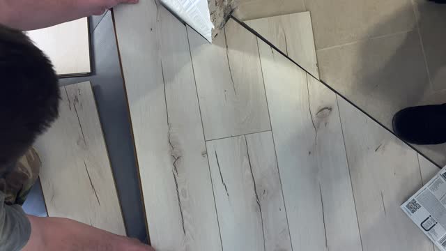 Repair.Floor and people concept - close-up of a person installing a wooden floor