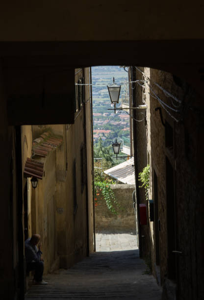 stretti passaggi tra le case per le strade dell'antica città di cortona, italia. - arezzo foto e immagini stock