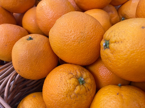 Many oranges in brown basket