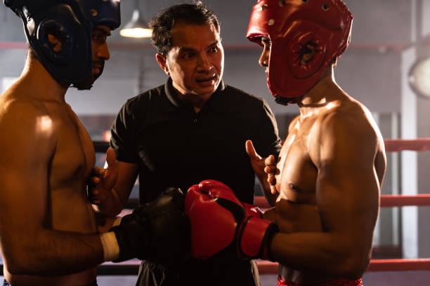 istock Boxer fighter with safety helmet face off with each other while referee. Impetus 1652404930
