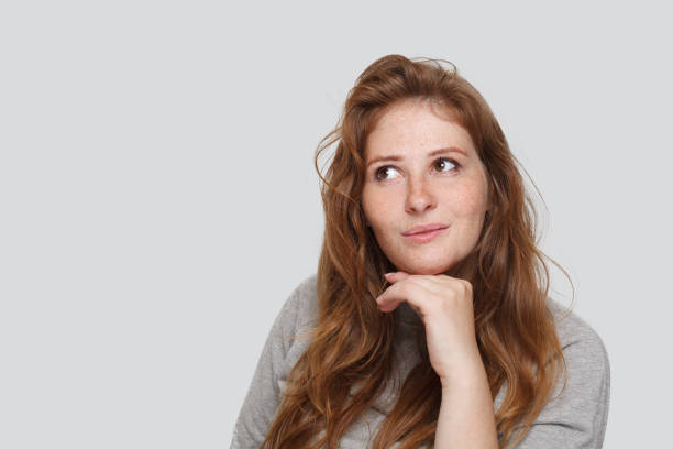 istock Cute redhead woman looking up on white background, studio portrait 1652407807