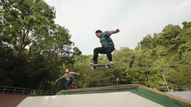 young male skateboarders in action mid air skate park