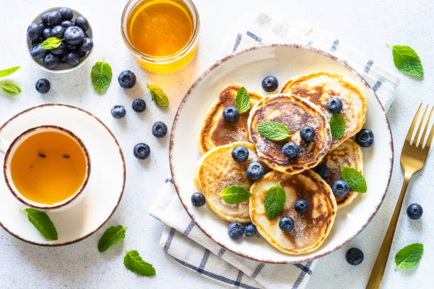 istock Pancakes with fresh blueberries and honey at white table. 1652465439