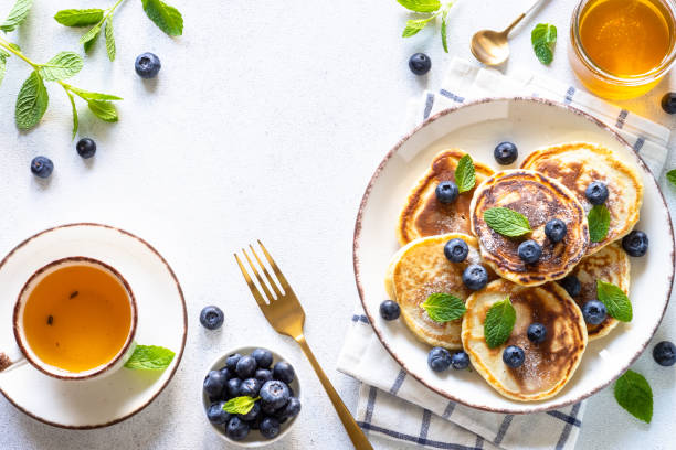 istock Pancakes with fresh blueberries and honey at white table. 1652465687