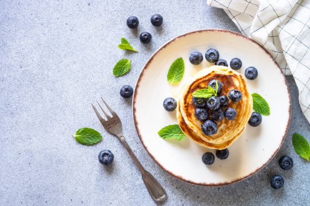 istock Pancakes with fresh blueberries and honey at white table. 1652466001