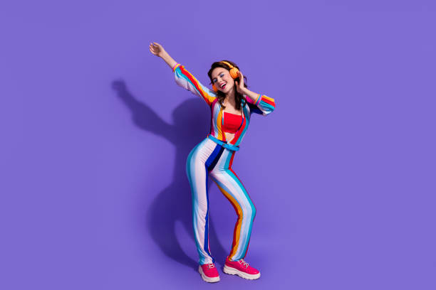 foto der fröhlichen positiven musikliebhaberin, die zum hören des stereo-sound-headsets isoliert auf violettem hintergrund verwendet wird - music women disco joy stock-fotos und bilder