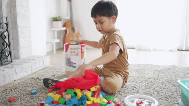 Asian children playing with wooden blocks on warm heated floor