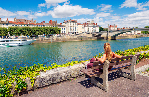 Woman sitting on a bench looking view of Chalon-sur-Saone- Burgundy in France