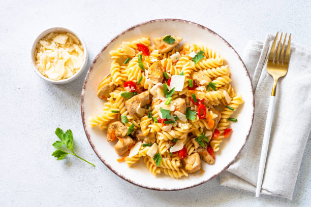 istock Italian pasta with tomato sauce, basil and parmesan cheese on white table. 1652479991