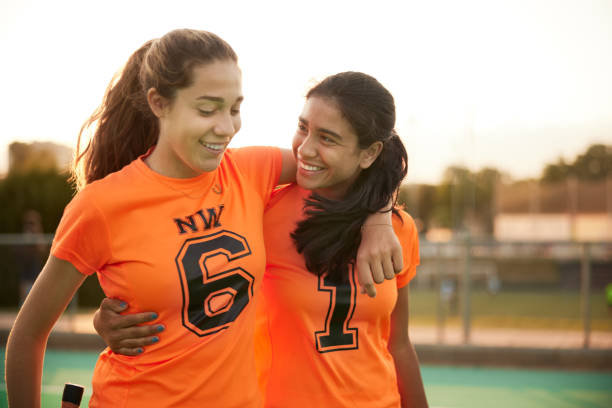 With arms over each other's shoulders, two players exit the field, their smiles reflecting the joy of winning a tournament.