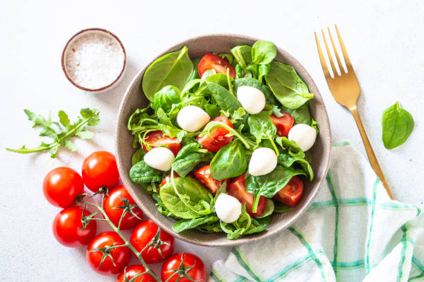 istock Green salad with fresh leaves, tomatoes and mozzarella. 1652503057