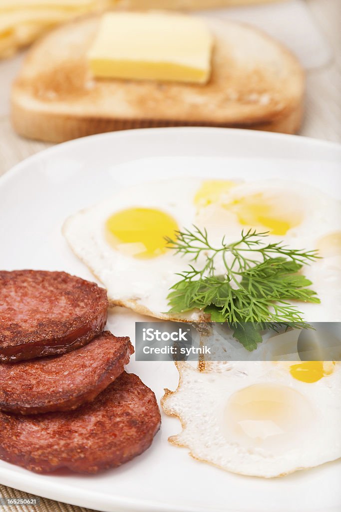 Prima colazione con salsicce e uova fritte, pane tostato su piatto - Foto stock royalty-free di Calore - Concetto