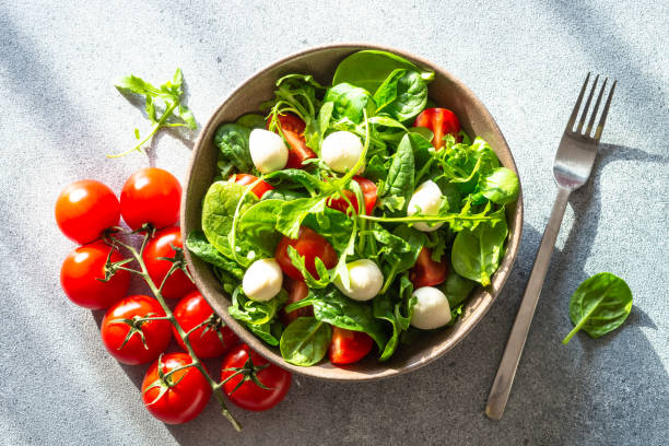 istock Green salad with fresh leaves, tomatoes and mozzarella. 1652506425