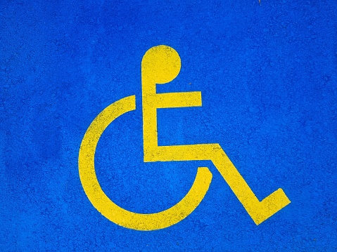 Symbol of a disabled parking space painted on asphalt