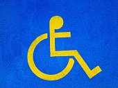 Symbol of a disabled parking space painted on asphalt