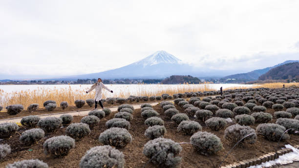 アジアの女性は、冬の季節に河口湖と富士山を旅します。