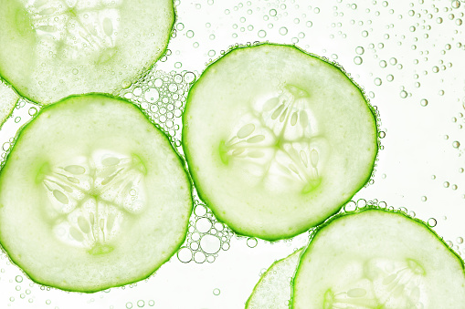 sliced cucumbers float on the surface of the water