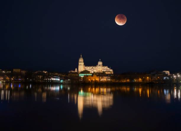 istock Spectacular lunar eclipse over the illuminated cathedral over Tormes river in Salamanca 1652536350