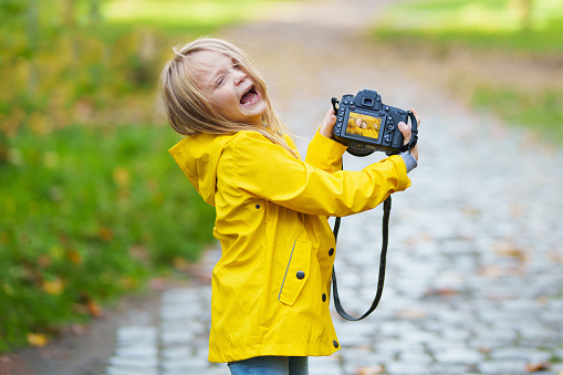 Smiling little girl Taking Pictures by DSLR