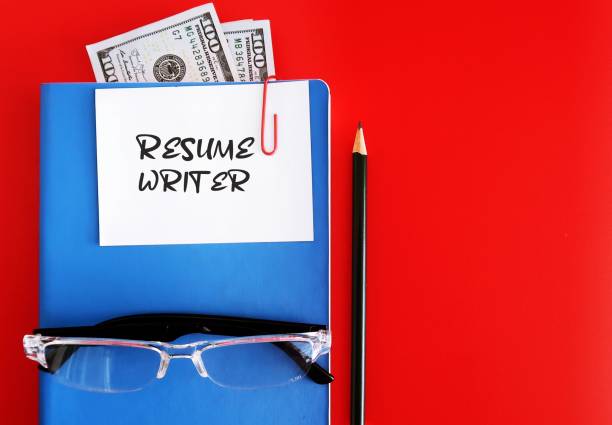 赤い背景に青いノートブック、鉛筆、現金のドル、メモが書かれた履歴書、より多くの面接の機会を得るために、求人応募履歴書サービスを提供するエキスパートライターのコンセプト - letter resume document writing ストックフォトと画像