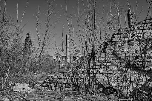 Abandoned sugar factory, brick chimneys, buildings with glassless windows, dilapidated brick fence, destruction, desolation and sadness