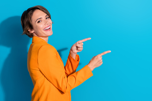 Side profile photo of young laughing woman bob hair recommend coworking zone location direct fingers ad isolated on blue color background.