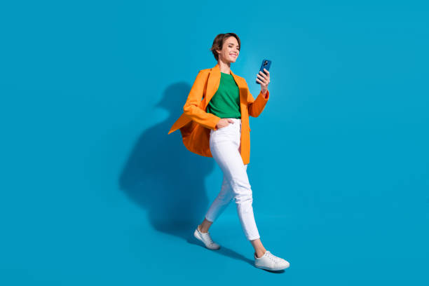 Full body size cadre of young optimistic project manager nice woman student communicating phone chat isolated on blue color background